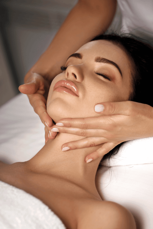 A woman getting a face massage and lymphatic drainage