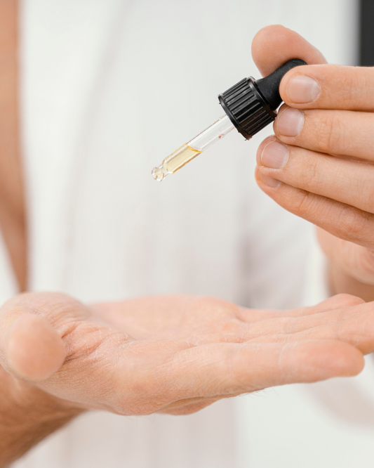 A woman dropping face oil on her palm