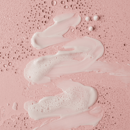 moisturiser texture shot. White moisturiser on pink background.