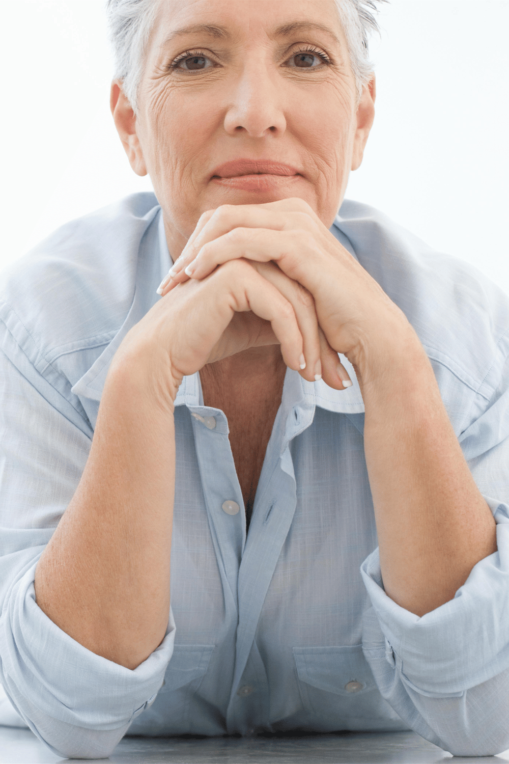 a headshot of a grey haired white woman looking directly in camera.