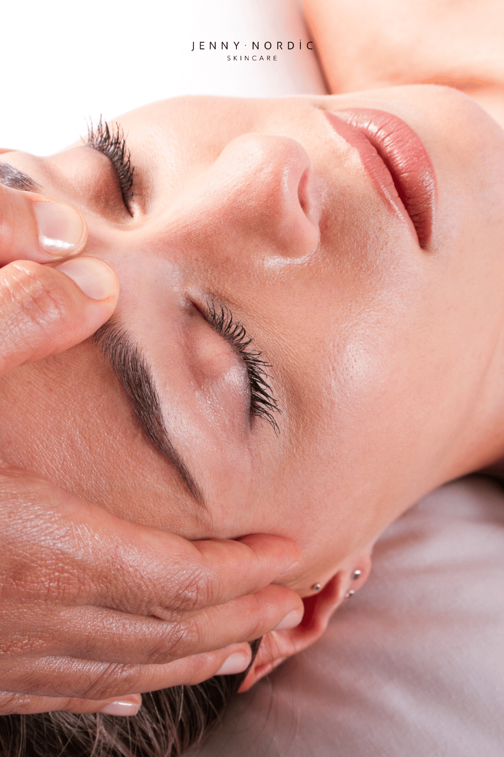 A woman receiving facial acupressure treatment