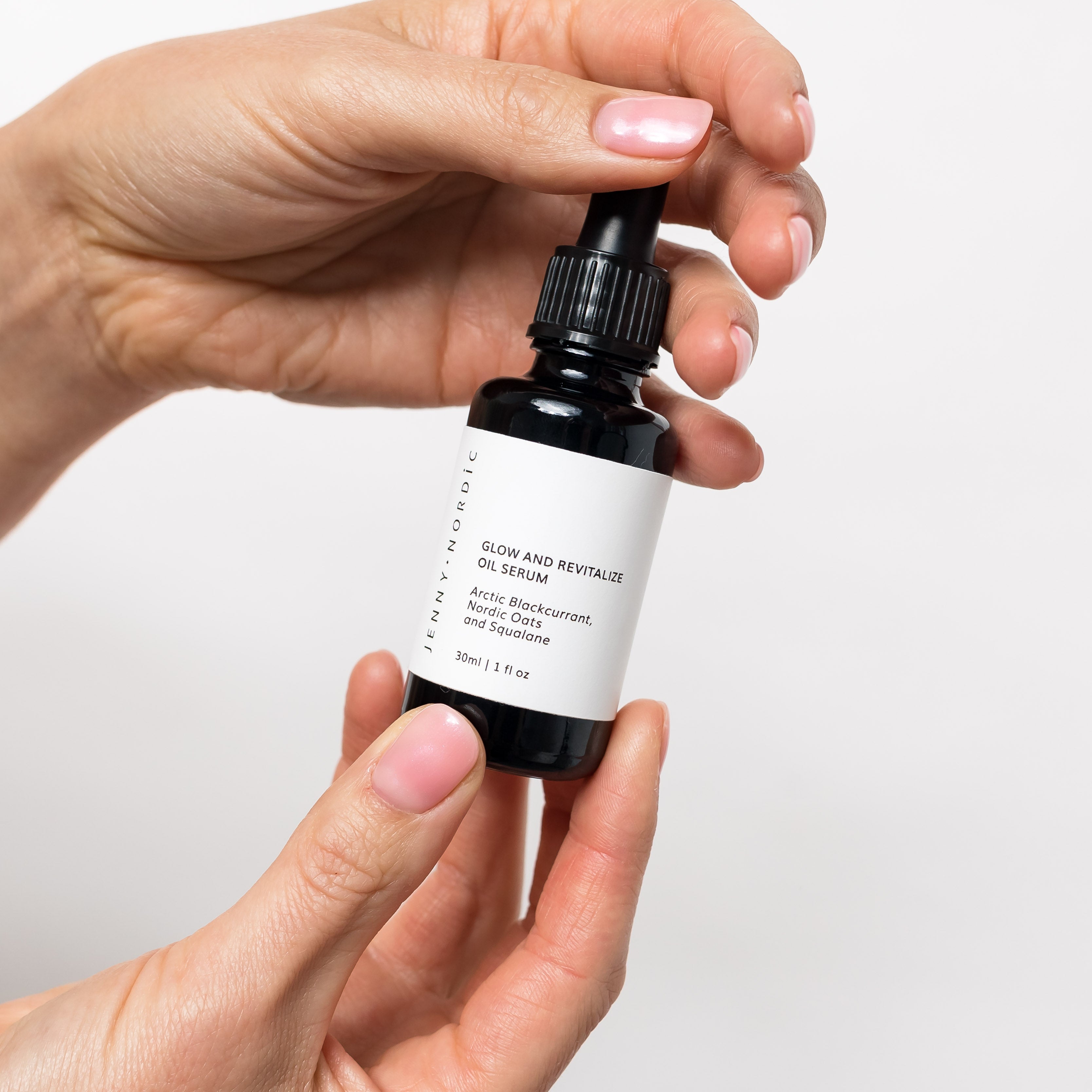Jenny Nordic Skincare | two hands holding Glow and Revitalize Oil Serum bottle